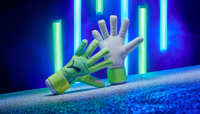 Luva de Goleiro Puma Ultra Ultimate Hybrid nas cores verde e azul, com dorso flexível e elementos de silicone para maior controle. Palma com látex 4mm Superior Grip para aderência em qualquer clima, corte híbrido para ajuste confortável e punho elástico com cinta de fechamento seguro. Modelo profissional usado por grandes goleiros.